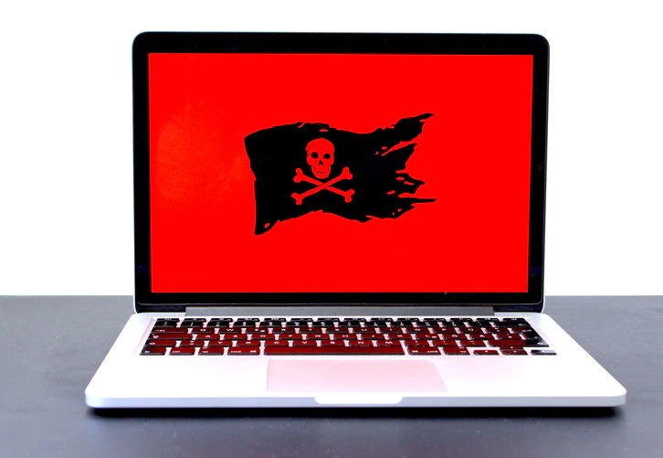 Notebook com a tela vermelha e uma bandeira de pirata no centro